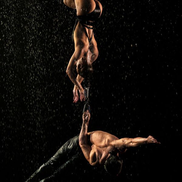 Silhouette of a man stretching against a dark background, representing balance and flexibility.